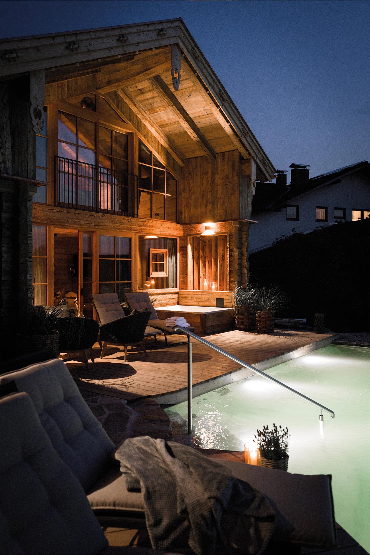 Outdoor Abendstimmung vor Chalet mit Badesee, Lounge und Whirlpool