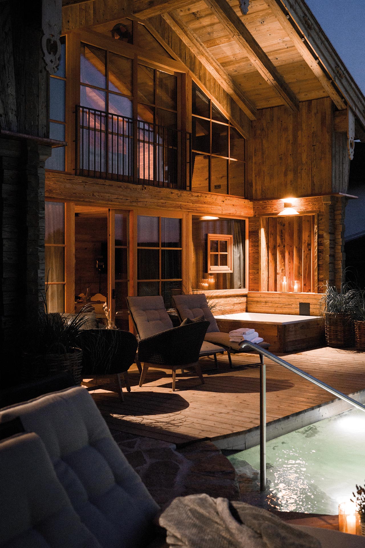 Abendstimmung vor Chalet mit Whirlpool, Lounge und Naturbadesee