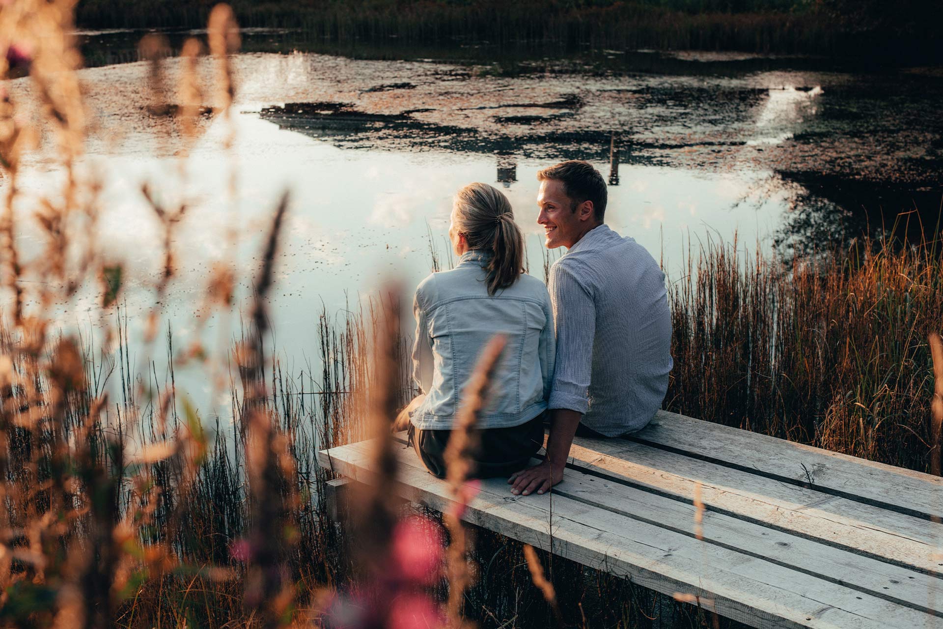 Ein Paar sitzt am Steeg des Mühlweihers und genießt die Aussicht